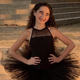 קבוצה מגוונת של צעירים קופצת מהתרגשות בגן ירוק ושופע במהלך אירוע קהילתי.