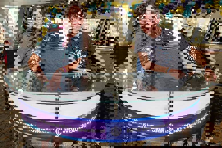 קהל מגוון של אנשים חוגג בקונצרט, מרימים את ידיהם ומריעים.