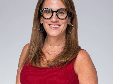 קהל מגוון של אנשים חוגג בקונצרט, מרימים את ידיהם ומריעים.