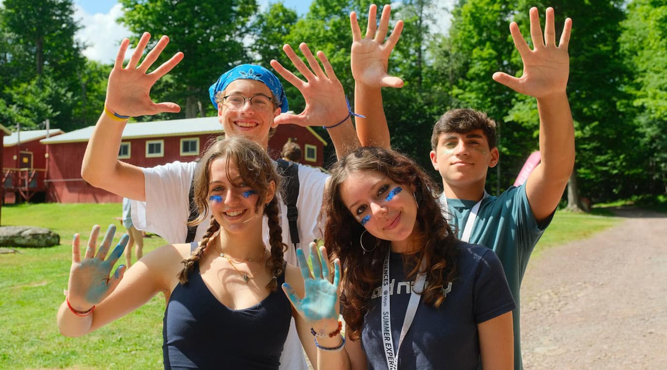 A diverse crowd of people celebrating at a concert, raising their hands and cheering.