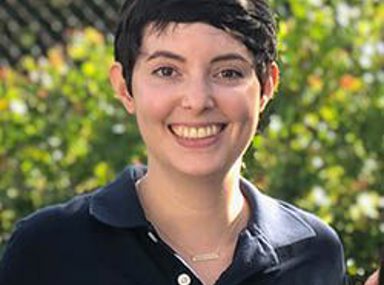 קהל מגוון של אנשים חוגג בקונצרט, מרימים את ידיהם ומריעים.