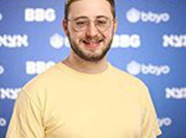 קהל מגוון של אנשים חוגג בקונצרט, מרימים את ידיהם ומריעים.