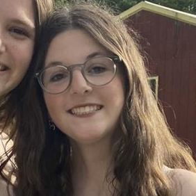 קבוצה מגוונת של צעירים קופצת מהתרגשות בגן ירוק ושופע במהלך אירוע קהילתי.