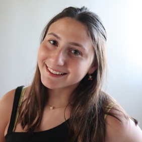 קבוצה מגוונת של צעירים קופצת מהתרגשות בגן ירוק ושופע במהלך אירוע קהילתי.