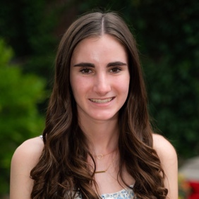 קבוצה מגוונת של צעירים קופצת מהתרגשות בגן ירוק ושופע במהלך אירוע קהילתי.