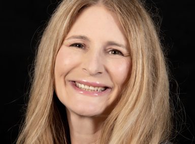 קהל מגוון של אנשים חוגג בקונצרט, מרימים את ידיהם ומריעים.