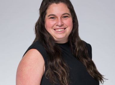 קהל מגוון של אנשים חוגג בקונצרט, מרימים את ידיהם ומריעים.