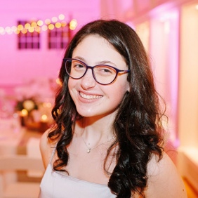 קבוצה מגוונת של צעירים קופצת מהתרגשות בגן ירוק ושופע במהלך אירוע קהילתי.