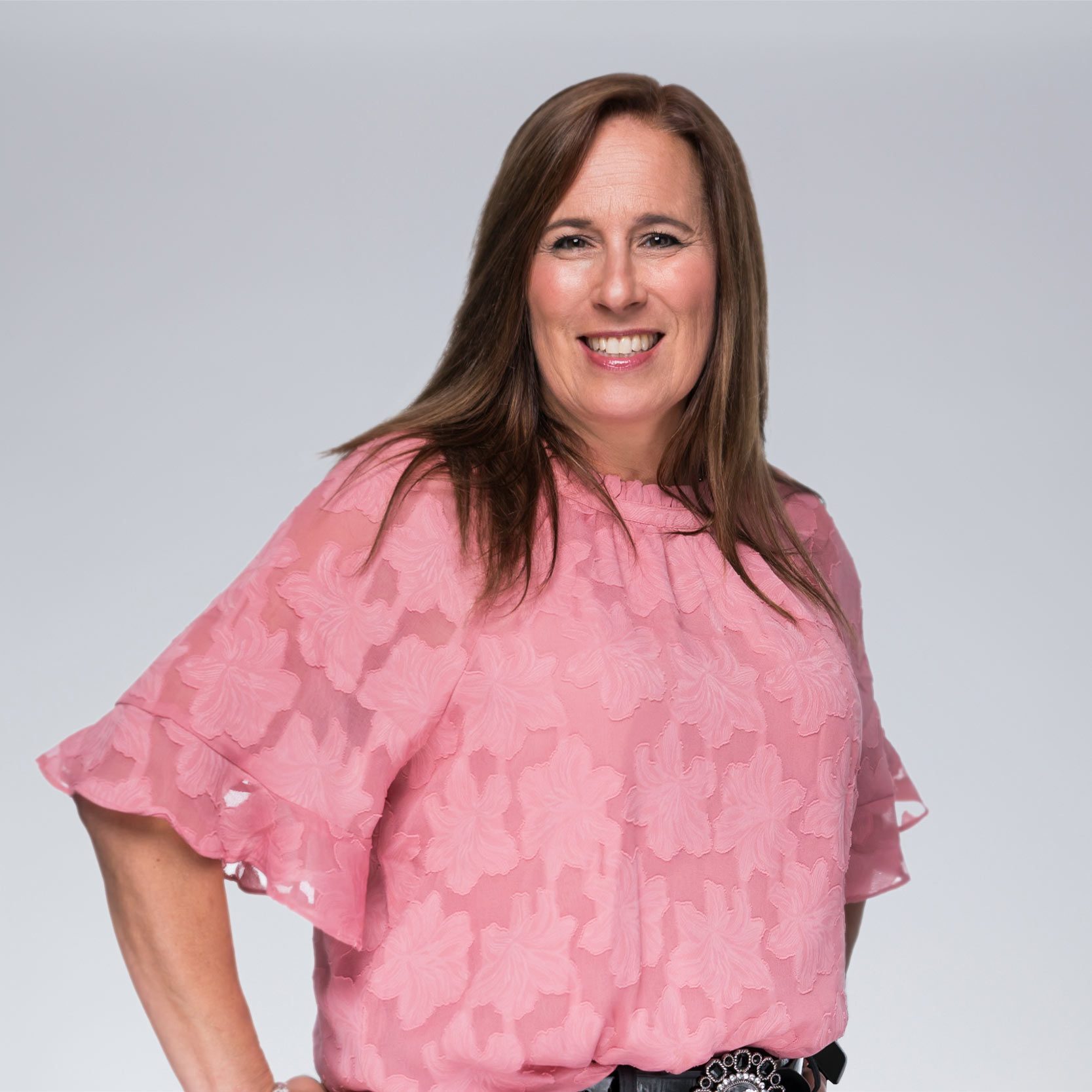 A diverse crowd of people celebrating at a concert, raising their hands and cheering.