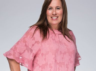 קהל מגוון של אנשים חוגג בקונצרט, מרימים את ידיהם ומריעים.