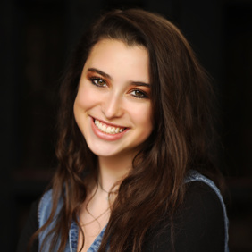 קבוצה מגוונת של צעירים קופצת מהתרגשות בגן ירוק ושופע במהלך אירוע קהילתי.