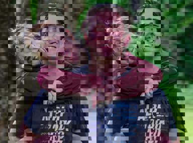 קהל מגוון של אנשים חוגג בקונצרט, מרימים את ידיהם ומריעים.