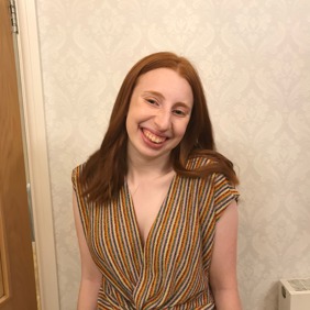 קבוצה מגוונת של צעירים קופצת מהתרגשות בגן ירוק ושופע במהלך אירוע קהילתי.