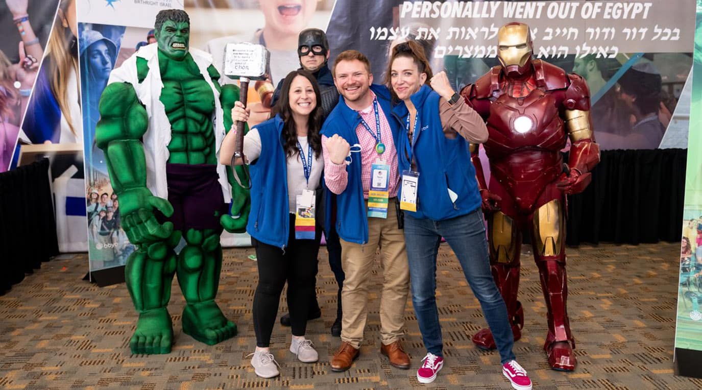 A diverse crowd of people celebrating at a concert, raising their hands and cheering.