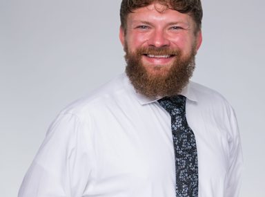 קהל מגוון של אנשים חוגג בקונצרט, מרימים את ידיהם ומריעים.