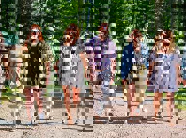 קהל מגוון של אנשים חוגג בקונצרט, מרימים את ידיהם ומריעים.